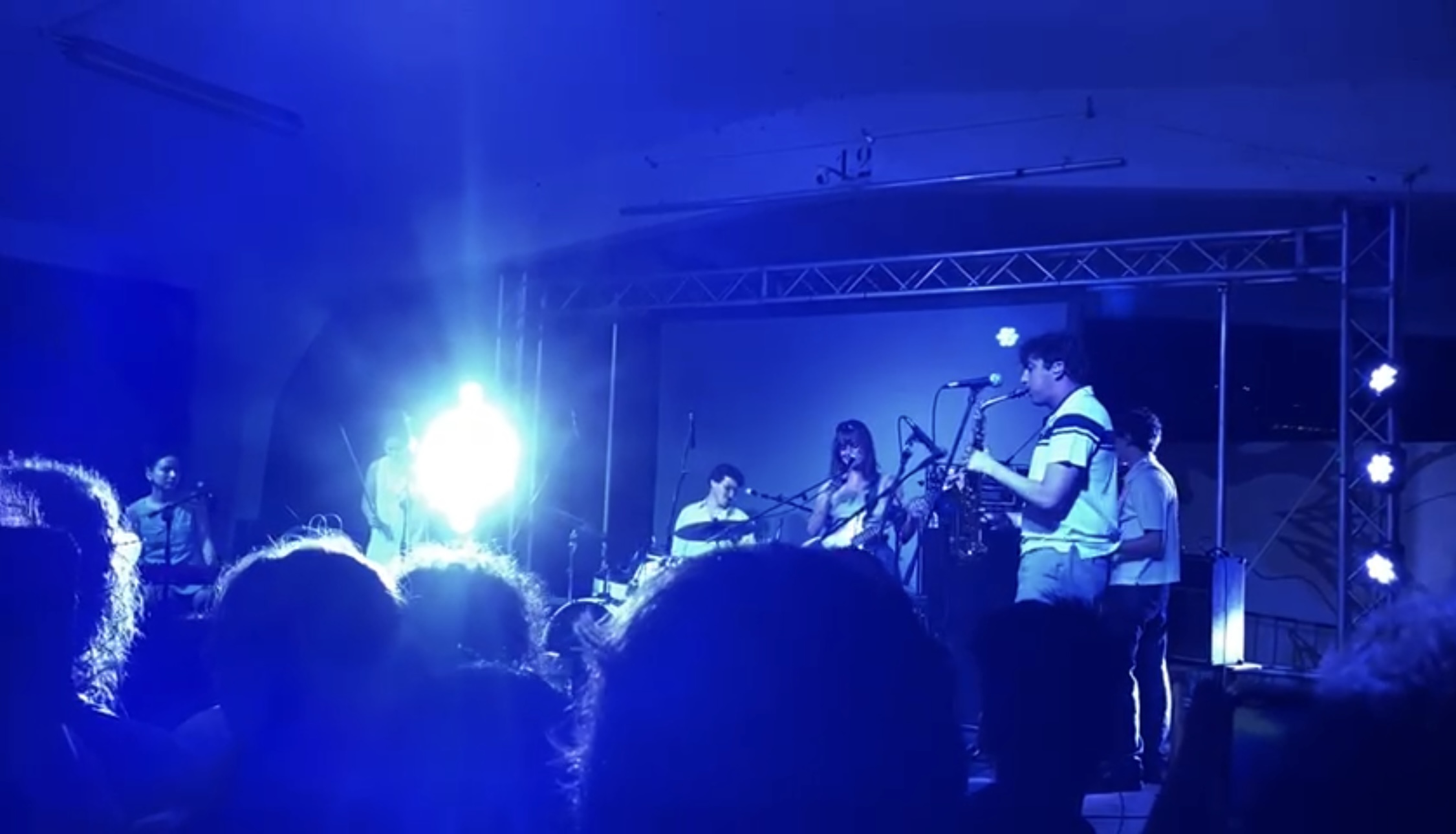 a group of people on stage at a concert in blue light